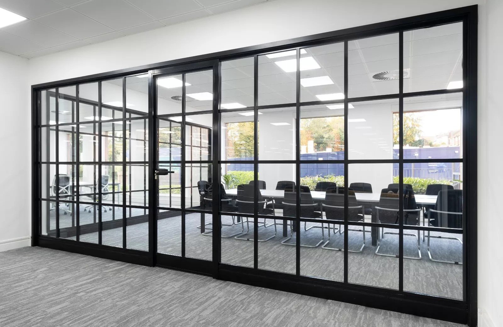 Crittall-style aluminium glass partition with black frame in office meeting room
