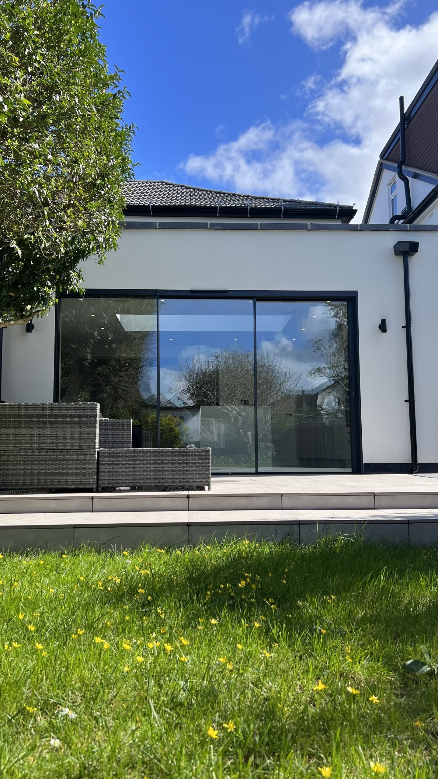 Modern villa exterior with full-height aluminium doors and landscaped garden