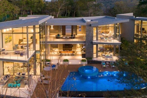 Heavily glazed aluminium villa elevation with floor-to-ceiling windows and sliding doors, a window-to-wall ratio well above 40%